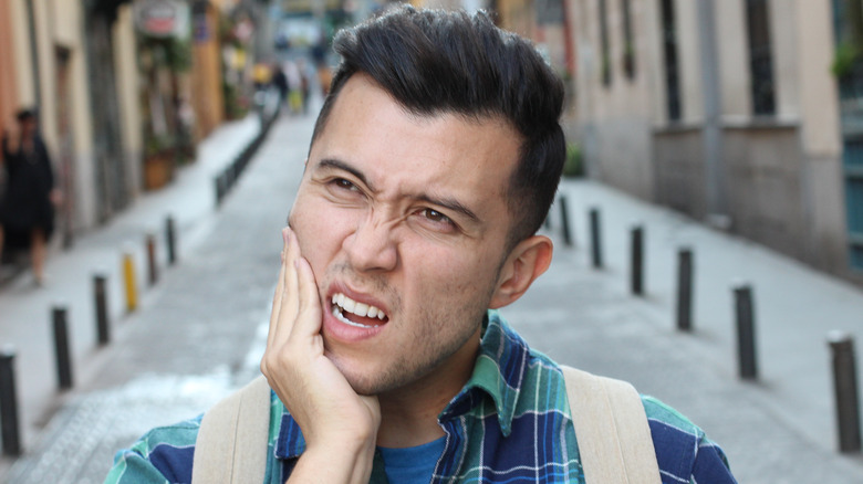 Man holding jaw in pain 