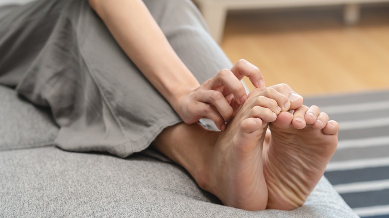 Woman scratching itchy feet