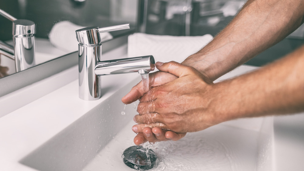 man washing his hands at the sink 