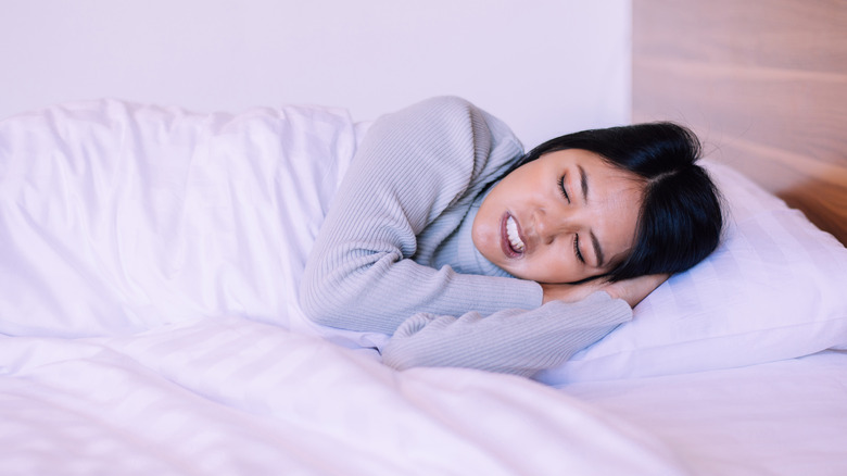 A woman grinding her teeth in her sleep