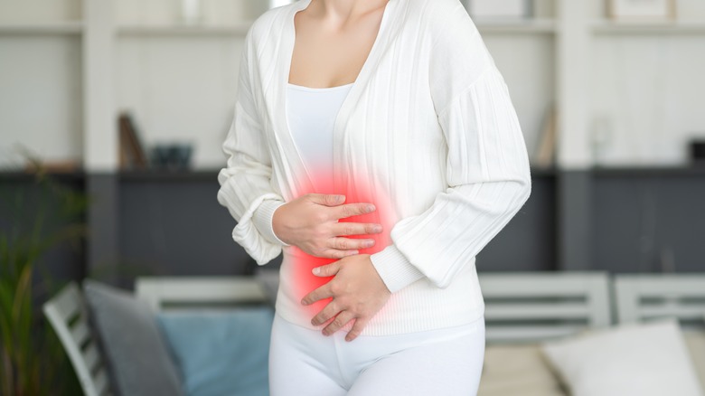 woman holding stomach pain