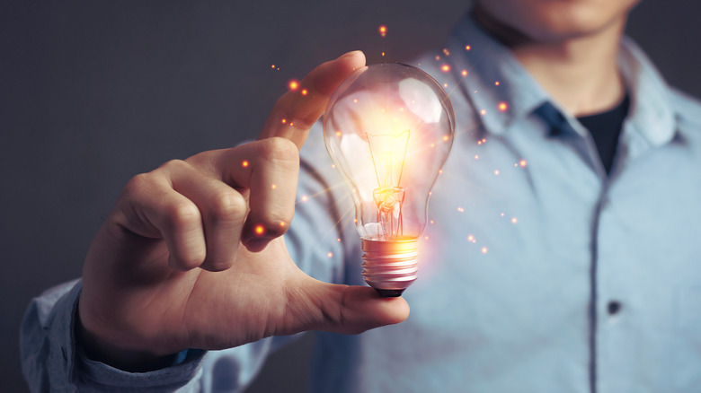 Man holding shiny light bulb 