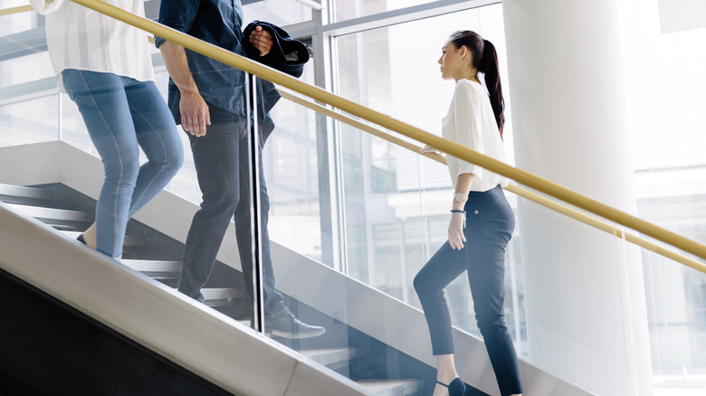 people dressed in business attire taking the stairs 