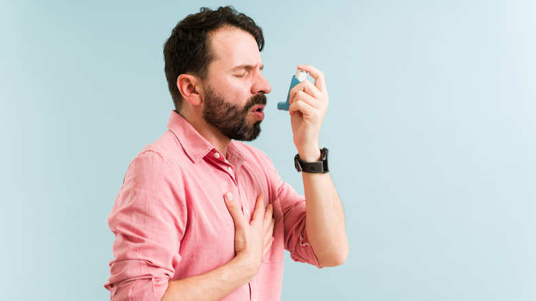 A man uses an asthma inhaler