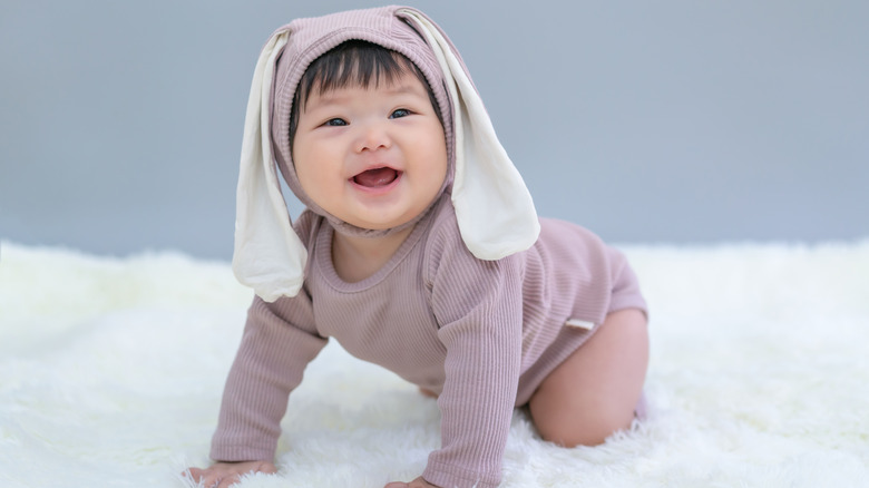 crawling baby wearing bunny ears