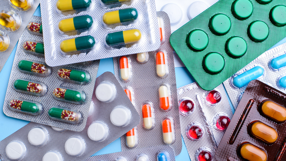 Different blister packs of pills in a messy pile together