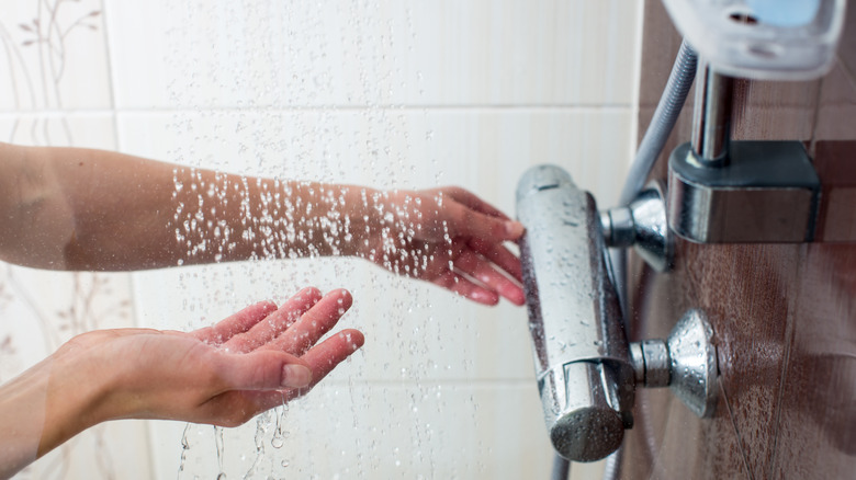 hand testing the water temperature