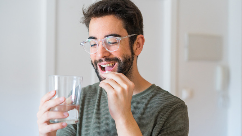 young man taking medication