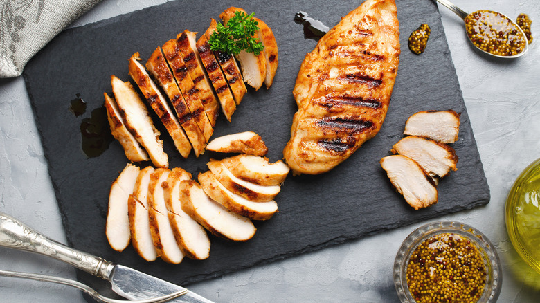 chicken breasts cut up on a cutting board