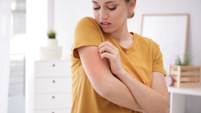 woman itching arm 