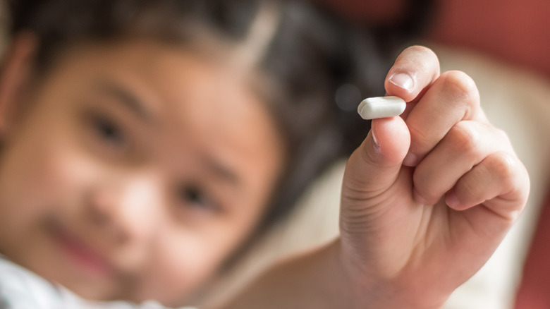 child holding white pill