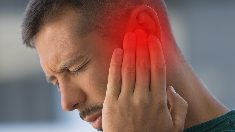 man with headache touching temple