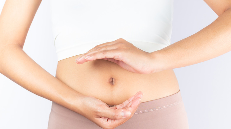 Woman holding her hands in front of her belly