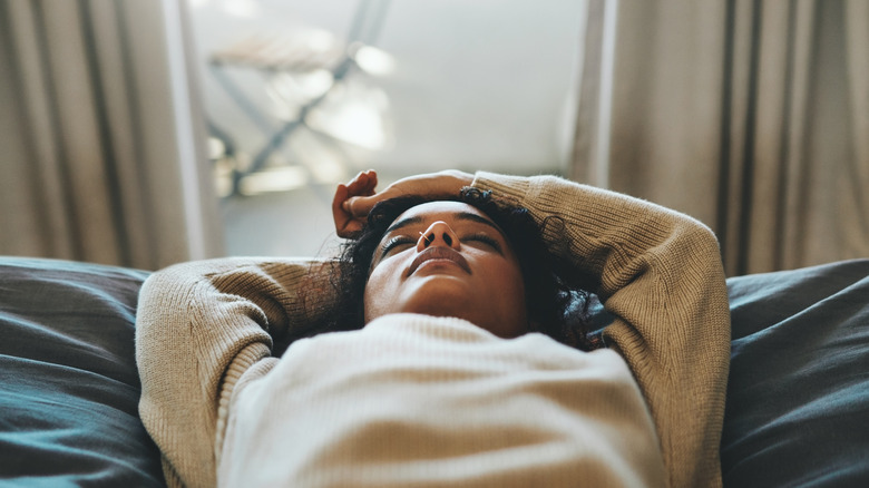 Tired woman lying on her bed