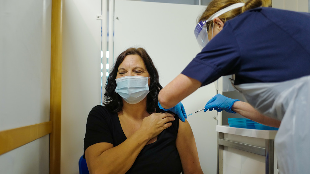 A woman receives the COVID-19 vaccine in England
