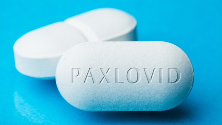 Two white pills with "Paxlovid" engraved on one side