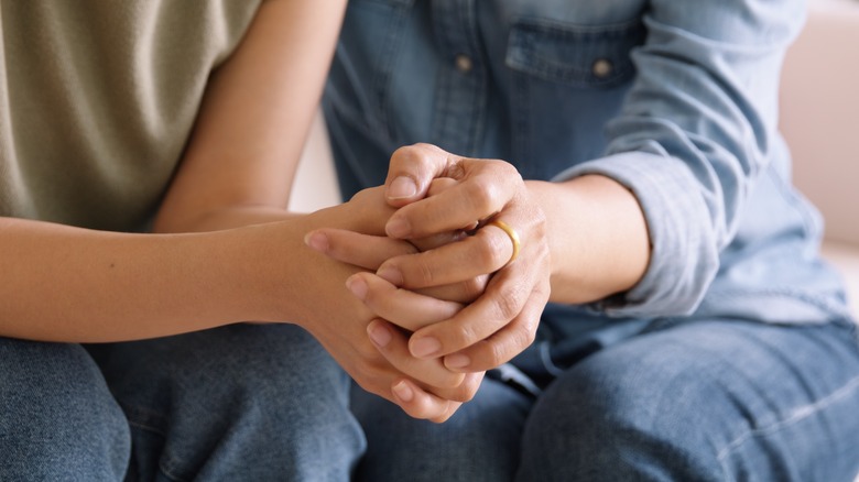 Couple holding hands with nail bed showing