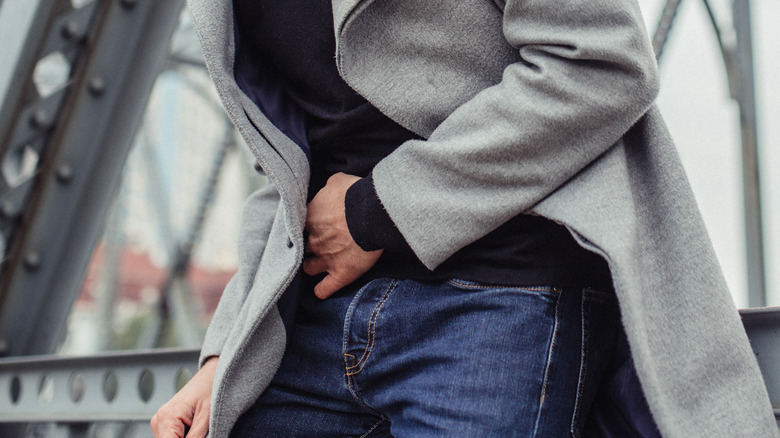 person on bridge experiencing intestinal pain