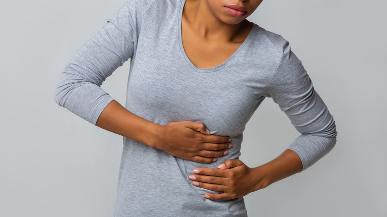 woman's hands holding her ribs