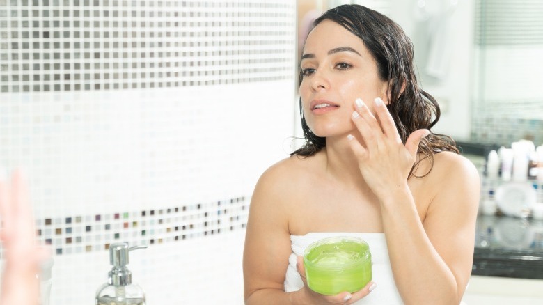 woman putting cream on face