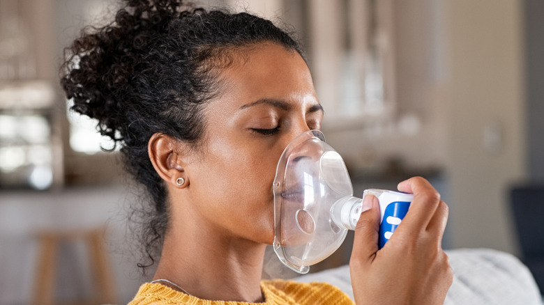 Black woman holding oxygen mask