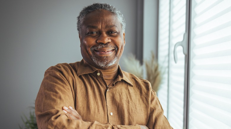 Older man standing by window