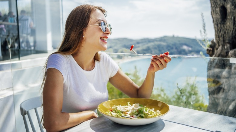 woman eating salad outdoors