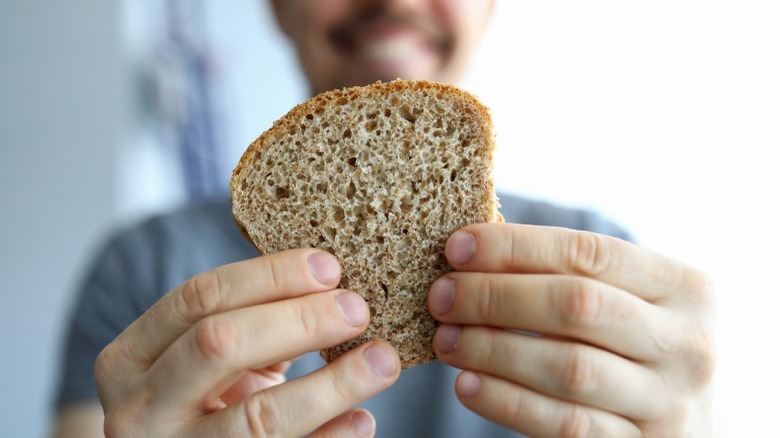 man holding whole grain bread