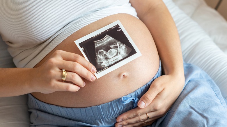 pregnant woman holding ultrasound image