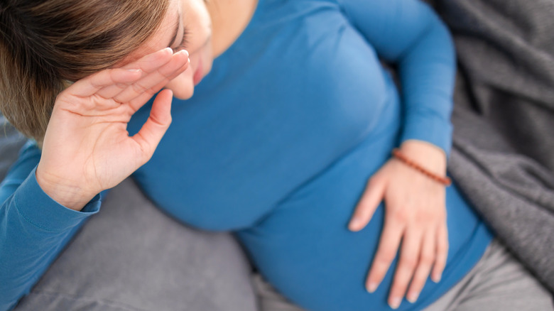 pregnant woman holding stomach