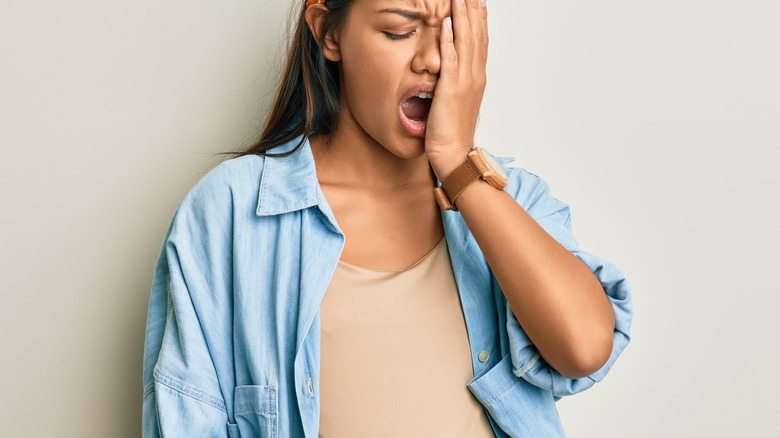 pregnant woman yawning while standing