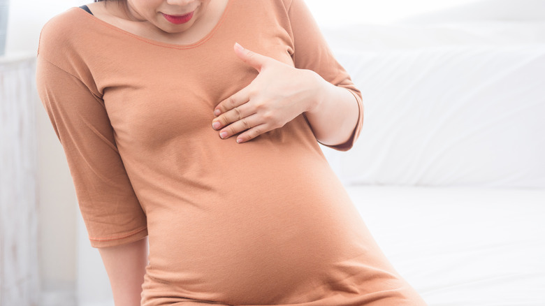 pregnant woman with holding chest 