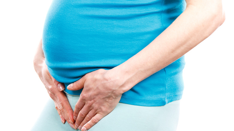 pregnant woman holding bladder