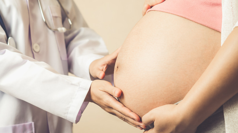 doctor touching womans belly