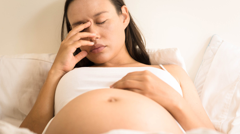 pregnant woman with hand on face 