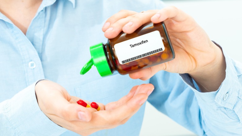 woman shaking out tamoxifen pills