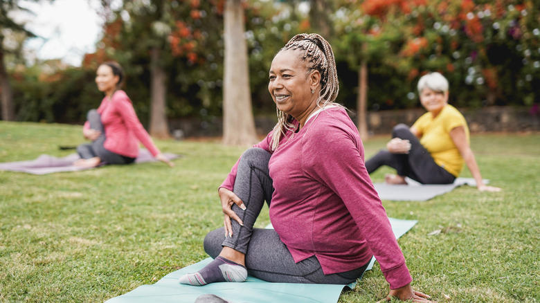 multiracial women doing yoga outside