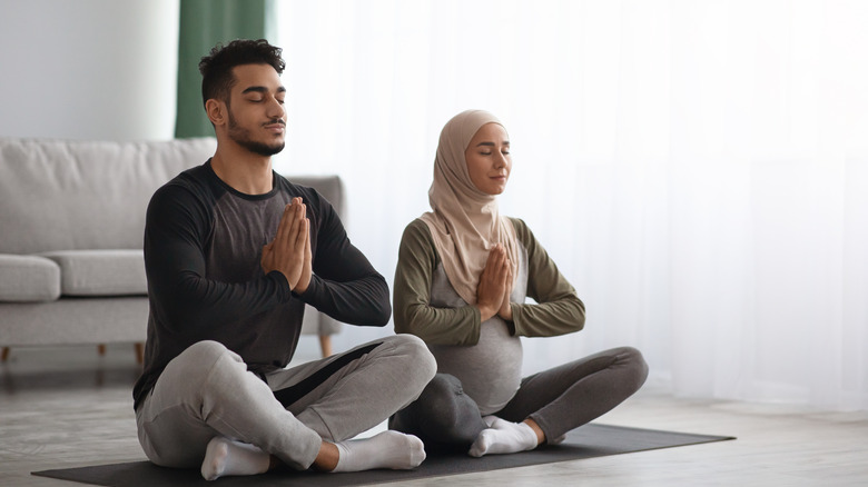 pregnant woman and husband meditating