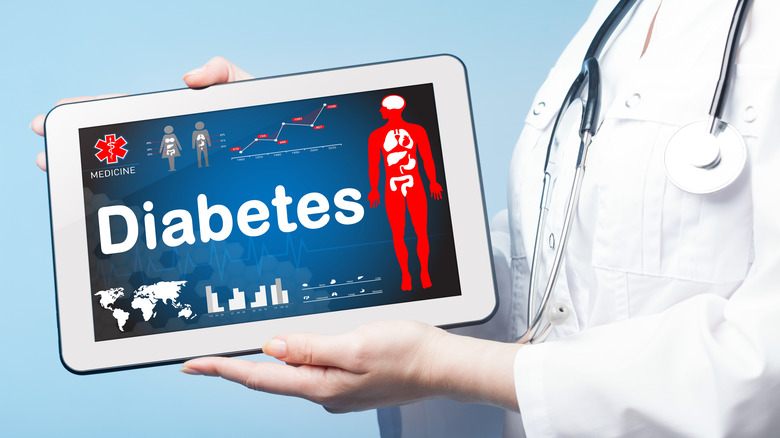 Doctor holding tablet displaying "diabetes"