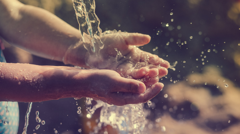 Child washing hands outdoors