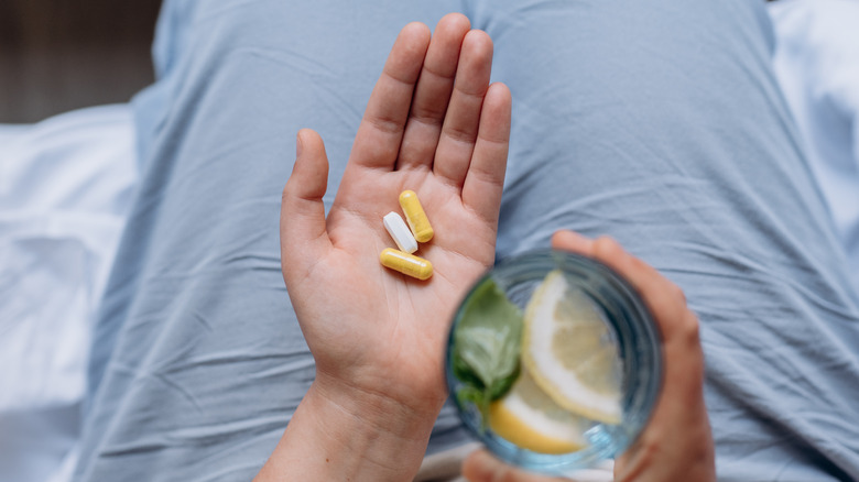 A woman pouring a magnesium supplement powder into a glass of water