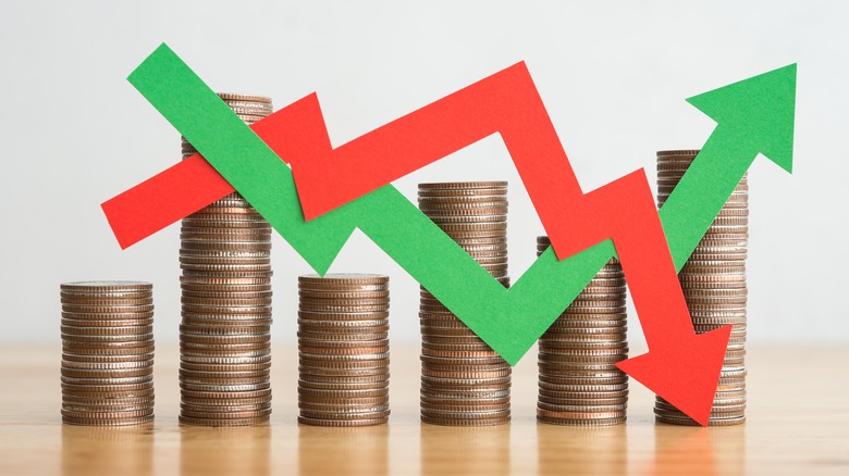 financial instability concept with stack of coins and red and green arrows