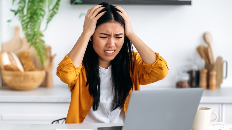 Woman looking stressed staring at her computer