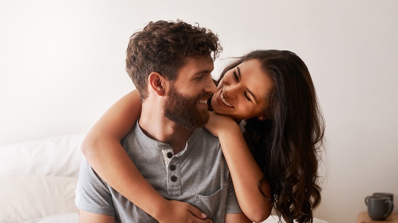 man and woman happily in bed