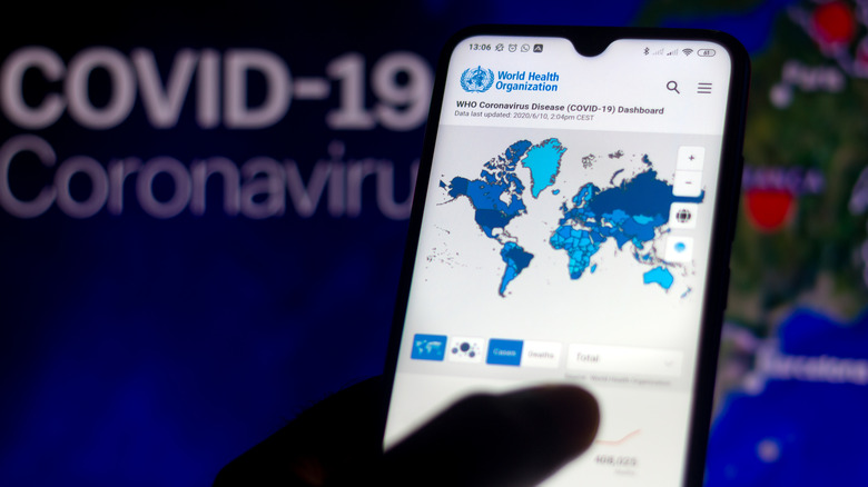 A world map of COVID cases on a phone