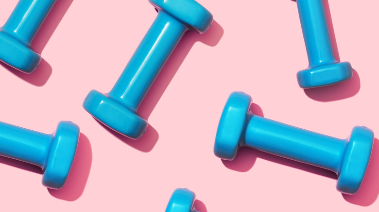 flat lay of blue dumb bells on pink background