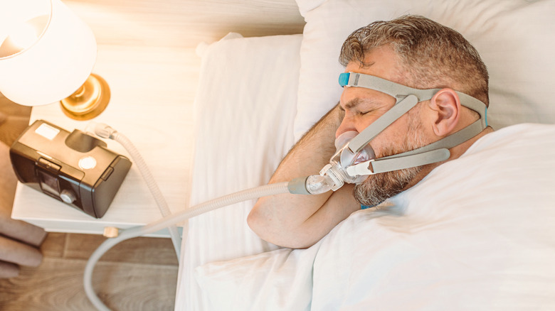 Sleeping man with CPAP machine