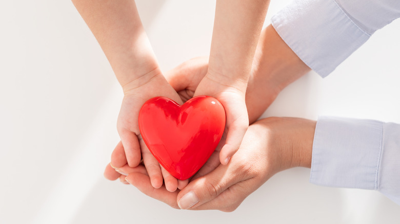 plastic heart in hands of child