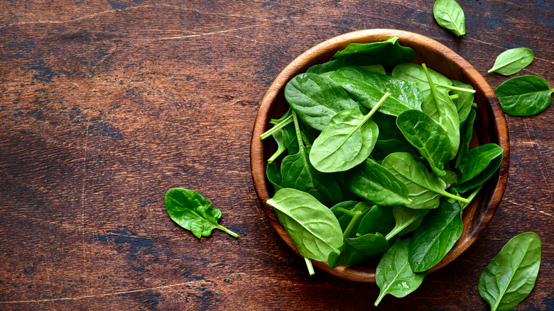 Overhead shot of spinach in wooden bowl