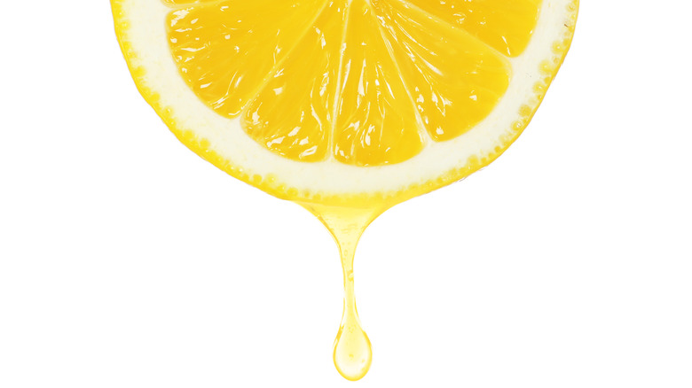 Lemon juice dripping from cut lemon